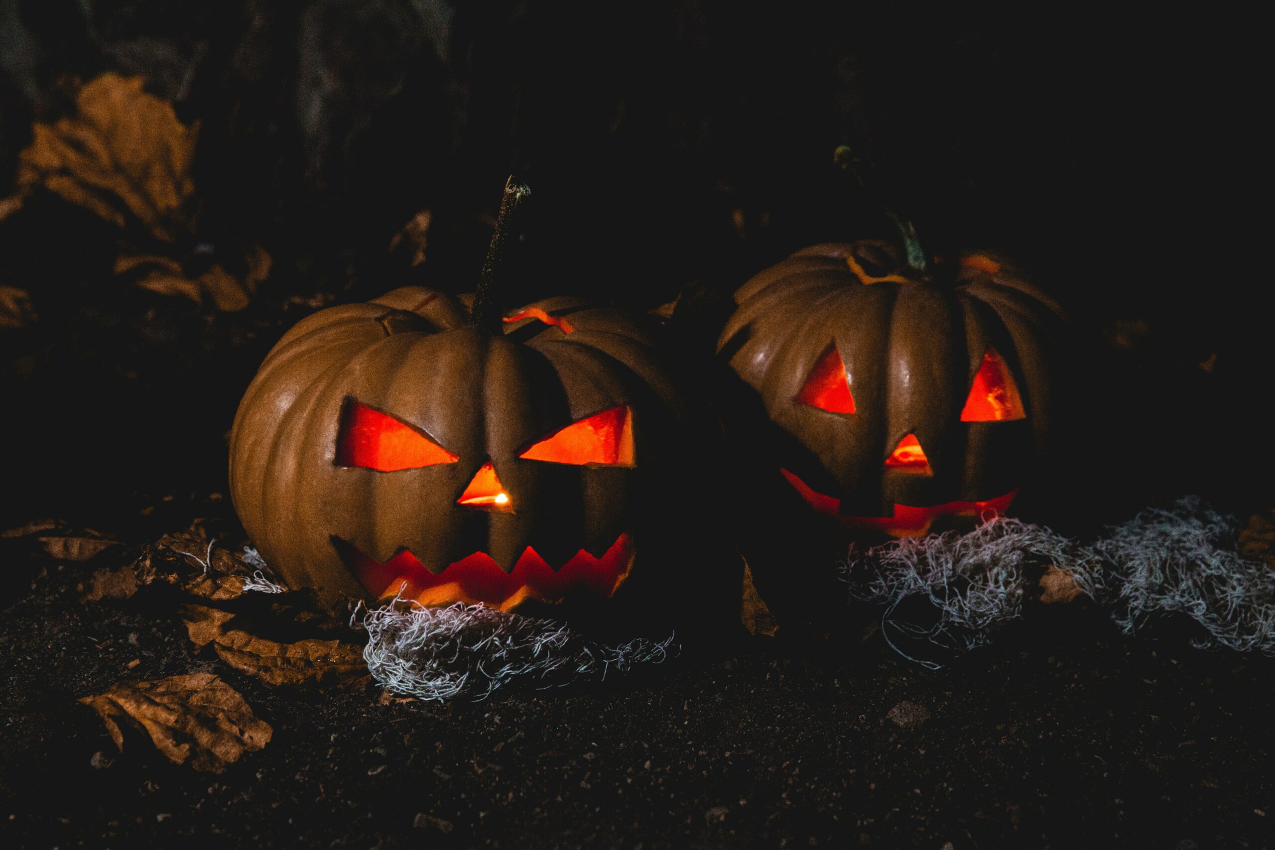 two carved pumpkins with red lights and spooky decorations at night | halloween activities Highlands Ranch